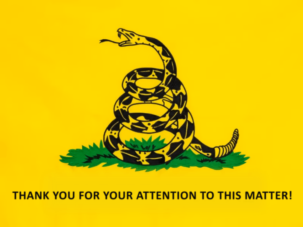 A Gadsden Flag (yellow flag with a snake and the words "Don't Tread On Me") with the words changed to say "THANK YOU FOR YOUR ATTENTION TO THIS MATTER!"
